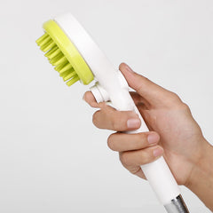 2-in-1 dog bath brush with shower head, held in hand, featuring green and white brush design for easy pet bathing.