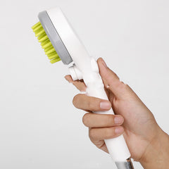 2-in-1 dog bath brush with shower head held in hand, featuring a green bristle design and ergonomic handle.
